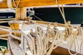 Yachting, wooden classical sailing boat, close-up of tied nautical ropes on wood cleats Royalty Free Stock Photo