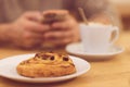 Detail image of unrecognisable man drinking coffee and holding smart phone while having breakfast in restaurant. Royalty Free Stock Photo