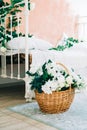 Detail of interior bright bedroom with decorative flowers in basket and wall Royalty Free Stock Photo