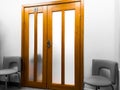 Detail of the interior, design - wide wooden doors and two office chairs next to them Royalty Free Stock Photo