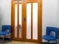 Detail of the interior, design - wide wooden doors and two office chairs next to them Royalty Free Stock Photo