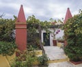 Detail from interior of the orthodox Monastery of Paleokastritsa, red pillars and door with flower pots and vine arbor with Royalty Free Stock Photo