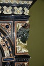 Marble face of the young lady on the retro chimney in the historical interior