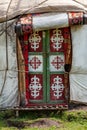 Detail of Kyrgyz yurt decorated door on grass in middle of the mountains. Yurts are traditional national buildings of local