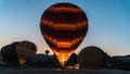 Detail of a large hot air balloon being inflated with fire at dawn