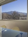 Detail of a large window overlooking nature and a glass table with two chairs in front Royalty Free Stock Photo