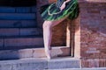 Detail of legs and feet of adult female Hispanic classical ballet dancer in green and black tutu with coins, performing figures Royalty Free Stock Photo