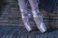 Detail of legs and feet of a woman classical ballet dancer illuminated by strips of small led lights, wearing a brown gauze Royalty Free Stock Photo