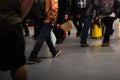 Detail of the legs of many tourists walking through the airport terminal