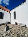 Detail of Lemvig church square with small art statue and seating area.