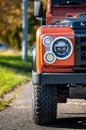 Detail on the light of an orange Land Rover Defender