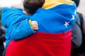Detail of little child hand on venezuelan flag as symbol of hope in future regime change, during march in support of Guaido