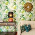 Detail of a living room with a sofa upholstered in beige fabric with green cushions, an industrial style sideboard and wallpapered