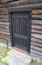 Detail of log cabin outer wall with closed wood door Royalty Free Stock Photo