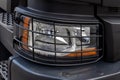 Detail of a lorry close up. Headlight of the truck under the protective grill. Truck electrical equipment. Road safety Royalty Free Stock Photo