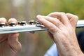 Male hands playing a flut.