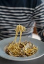 Detail male hand eating pasta spaghetti with clams and mullet, Mediterranean food