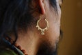 Male head wearing oriental Indian style hamsa fatima hand brass earring Royalty Free Stock Photo