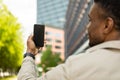 Detail of a man with a mobile phone in his hands, photographing the city