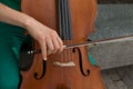 Detail of a man playing the wooden cello rubbing the strings with the bow to get the notes of a classical music piece