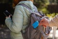 Detail of a man`s hand stealing a credit card from a woman`s backpack outdoors Royalty Free Stock Photo