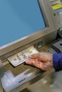 Detail of a man\'s hand taking dollar bills out of an ATM Royalty Free Stock Photo