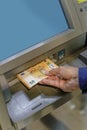 Detail of a man\'s hand taking euro bills out of an ATM Royalty Free Stock Photo