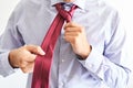 Detail of a man tying his tie blue