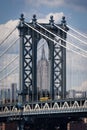 Detail of the Manhattan Bridge with a school bus and the Empire State Builing on the background