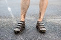 Detail of mens legs in cycling spikes after ride in wet and muddy terrain