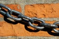 Metal chain lying on terracotta bricks wall Royalty Free Stock Photo