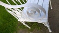 Detail of metal vintage white bench. Empty chair in the garden. Place for relaxation and inspiration. Concept of ecology and comfo Royalty Free Stock Photo