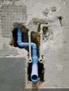 Detail of metal water pipes and PVC drain pipe blue color appear in smashed bathroom wall,Under-construction condominium site. Royalty Free Stock Photo