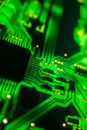 Detail of a microprocessor, resistors and capacitors soldered to a green glowing PCB Royalty Free Stock Photo