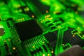 Detail of a microprocessor, resistors and capacitors soldered to a green glowing PCB Royalty Free Stock Photo