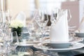 Detail of modern banquet setting on glass table. Blurry background