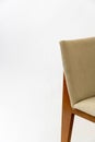 Detail of a modern chair with a white fabric seat and wooden legs isolated on a white background Royalty Free Stock Photo