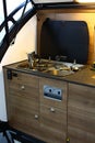 Detail of modern mobile kitchen from rear part of Bushcamp trailer campervan, with small sink and two burners.