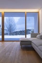 Detail of modern sofa in living room with large windows, view of nature and snow Royalty Free Stock Photo