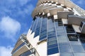 Detail of modern urban architecture - the building on blue sky background of concrete and glass with balcony, located in spiral. Royalty Free Stock Photo