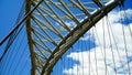 Detail Of Modern White Metal Bridge With Steel Support Wires Seen From Below With Blue Sky And Clouds