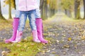 detail of mother and daughter wearing rubber boots in autumnal a