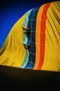 Detail of multicolored fabric of a hot air balloon deflating, vertical image