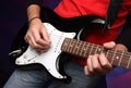 Detail of a musician playing a black electric guit Royalty Free Stock Photo