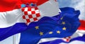 Detail of the national flag of Croatia waving in the wind with blurred european union flag in the background on a clear day