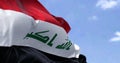 Detail of the national flag of Iraq waving in the wind on a clear day