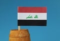 A detail on national flag of Iraq on wooden stick in wooden barrel.