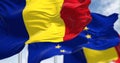 Detail of the national flag of Romania waving in the wind with blurred european union flag