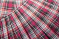 Detail of new fashion plaid pleated skirt: red, maroon, gray tartan school uniform fabric cotton/woolen material Royalty Free Stock Photo