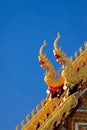 A detail of northern thai temple roof ,Naga , under clear blue sky Royalty Free Stock Photo